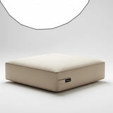 A single, square box-style seat cushion in a solid light beige color. The cushion is shown from a three-quarters angle and is isolated on a plain white background.