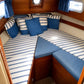 Custom blue striped boat cabin cushions for cozy V-berth seating