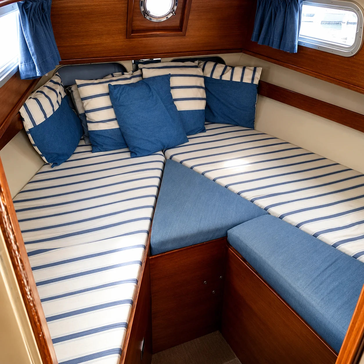 Custom blue striped boat cabin cushions for cozy V-berth seating