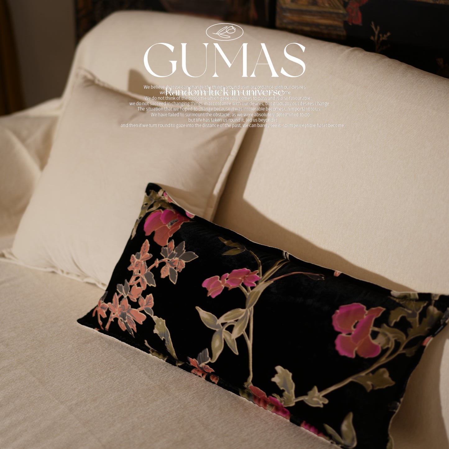 Black floral throw pillow styled on modern sofa with pink and coral blooming flowers