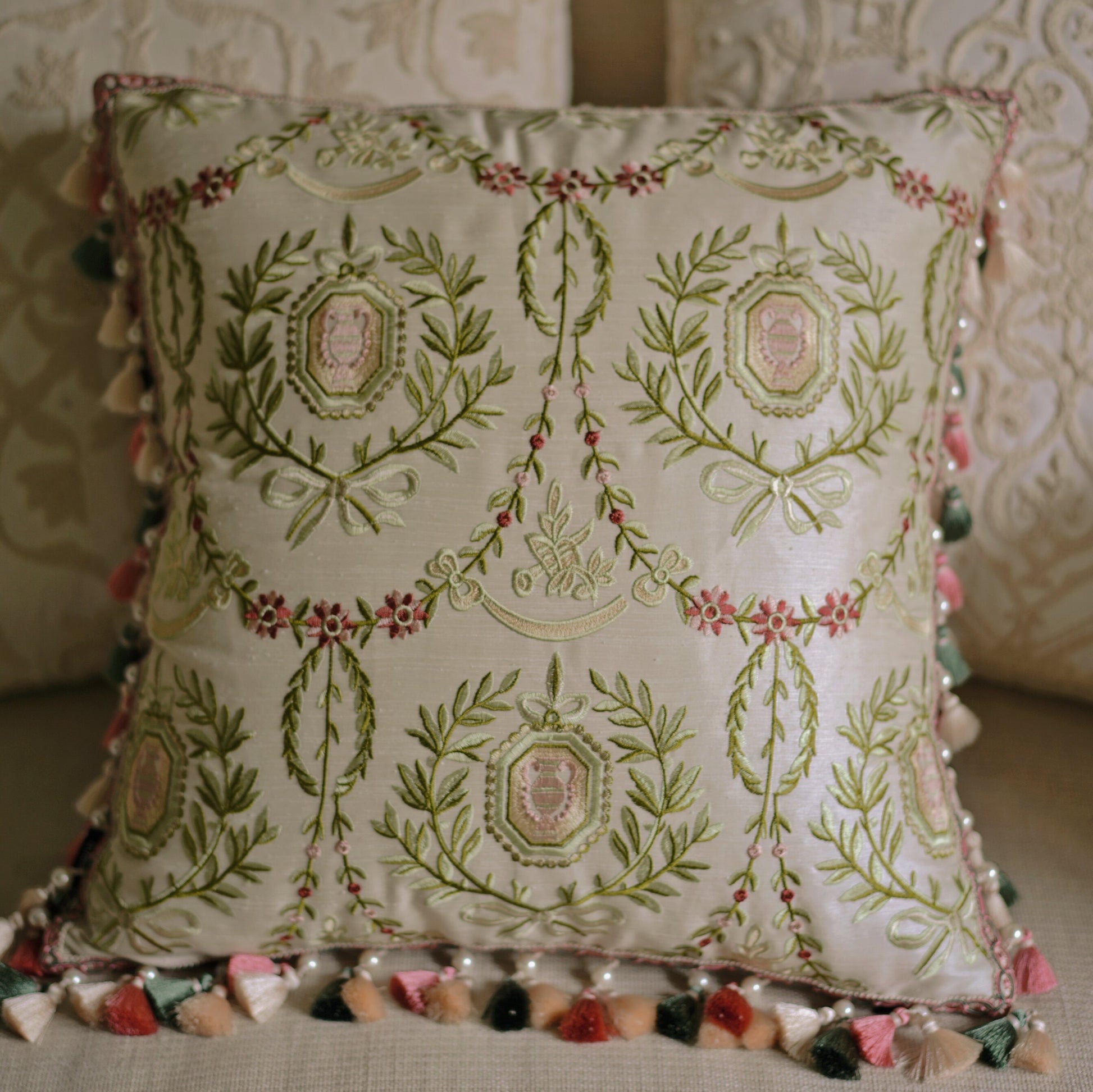 Botanical throw pillow detail showing raised embroidery work and ornate scrollwork pattern