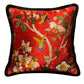 Close-up of hand-embroidered hummingbird detail on burgundy velvet cushion showing dimensional texture