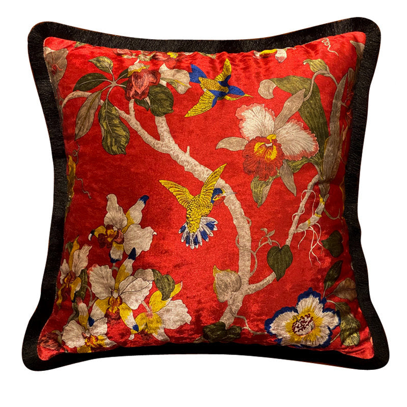 Close-up of hand-embroidered hummingbird detail on burgundy velvet cushion showing dimensional texture