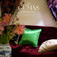 Close-up of multicolored floral embroidery with gold thread and beadwork on vibrant green silk cushion cover