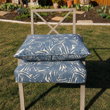 Custom blue palm leaf outdoor dining chair cushion for a patio