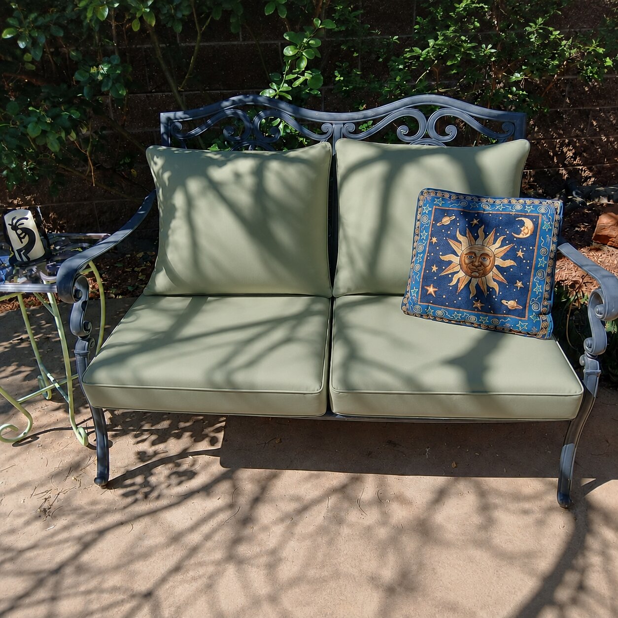 Custom sage green outdoor loveseat cushions for a metal patio bench