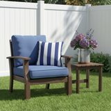 Deep seat outdoor cushions in navy blue and patterned fabric set in a lively garden.