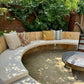 firepit-curved-bench-cushion-white-throw-pillows-garden