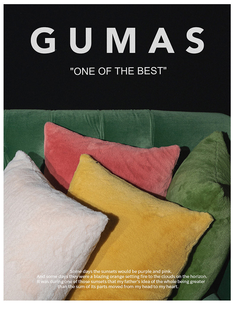 Forest green faux fur cushion cover styled with teal and coral accent pillows
