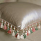 French palace-style embroidered cushion with mixed tassel trim in cream, pink, sage, and ivory