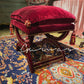 Geometric Persian rug pattern detail in burgundy, blue, orange and gold on velvet ottoman