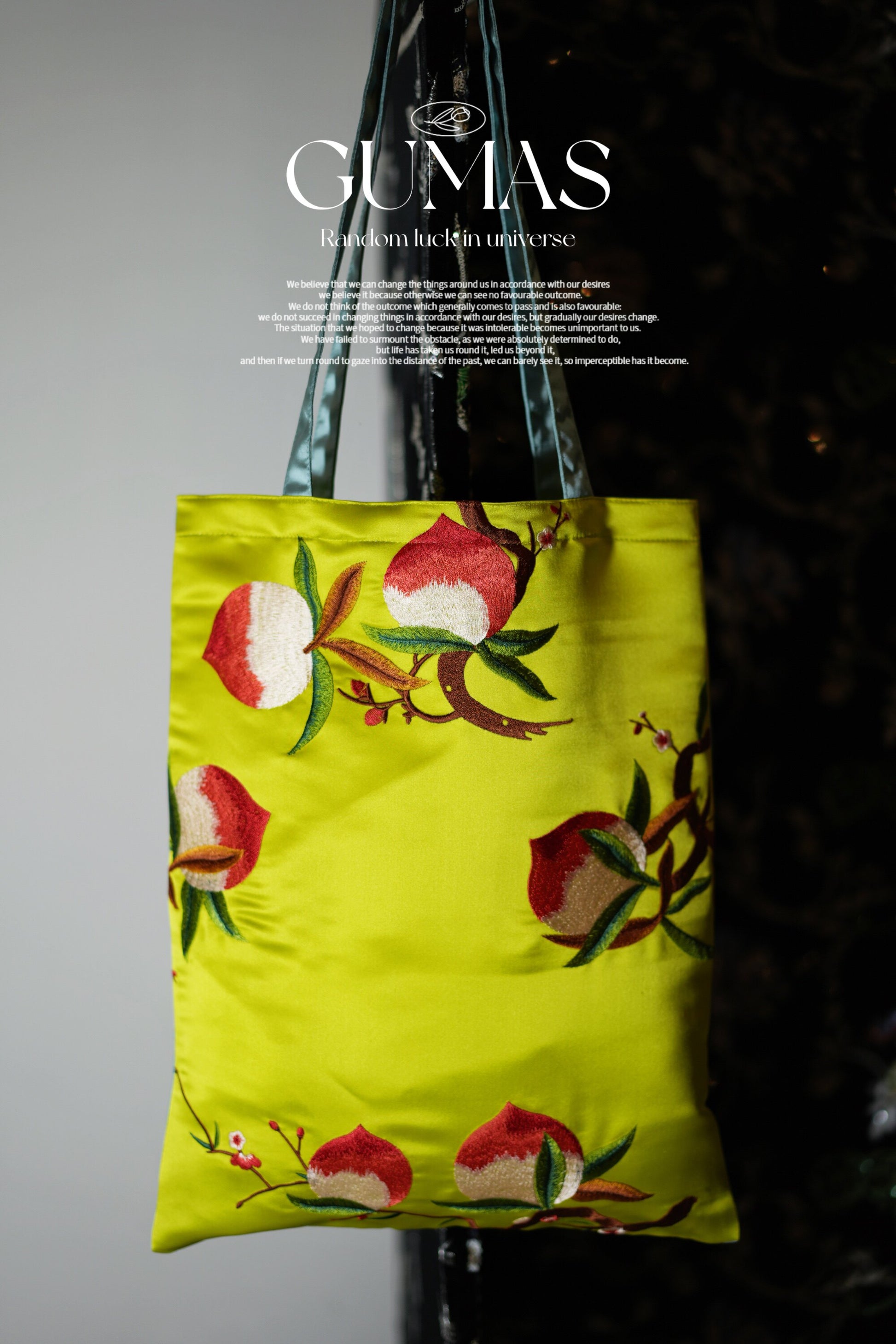 Hand-embroidered botanical silk pouch showing detailed red peach blossom and green leaf work