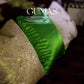 Lime green embroidered pillow styled with burgundy velvet sofa and botanical print accent cushions
