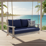 Outdoor swing cushion in deep green fabric surrounded by lush plants