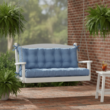 Outdoor swings with cushions in deep green and blue colors, set in a vibrant garden.