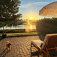 Outdoor chaise lounge cushions in white on poolside deck at sunset